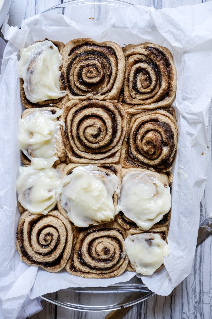 a plate of cinnamon rolls with several frosted