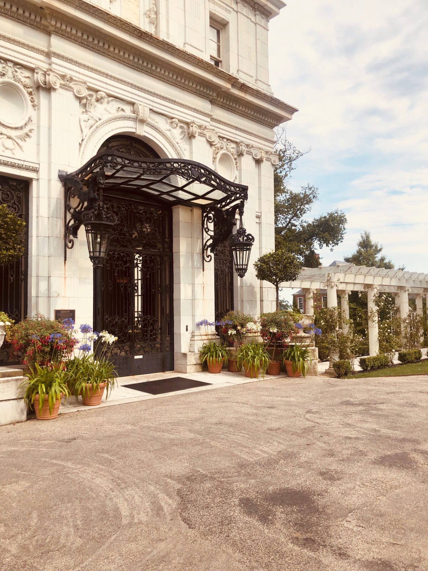 a mansion entrance with an ornate black cast iron door