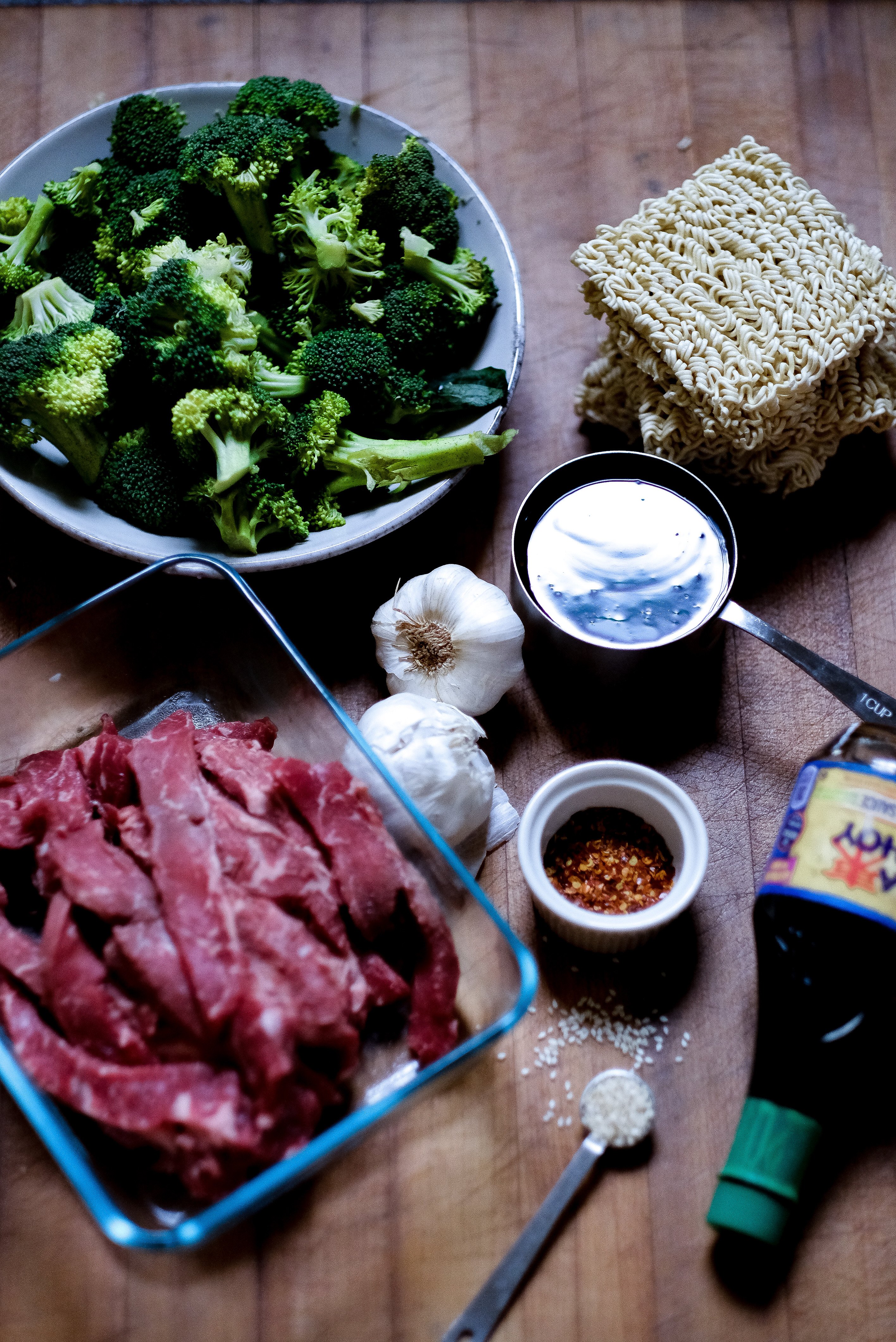 ingredients for making a recipe include broccoli, ramen noodles, strips of beef and soysuace