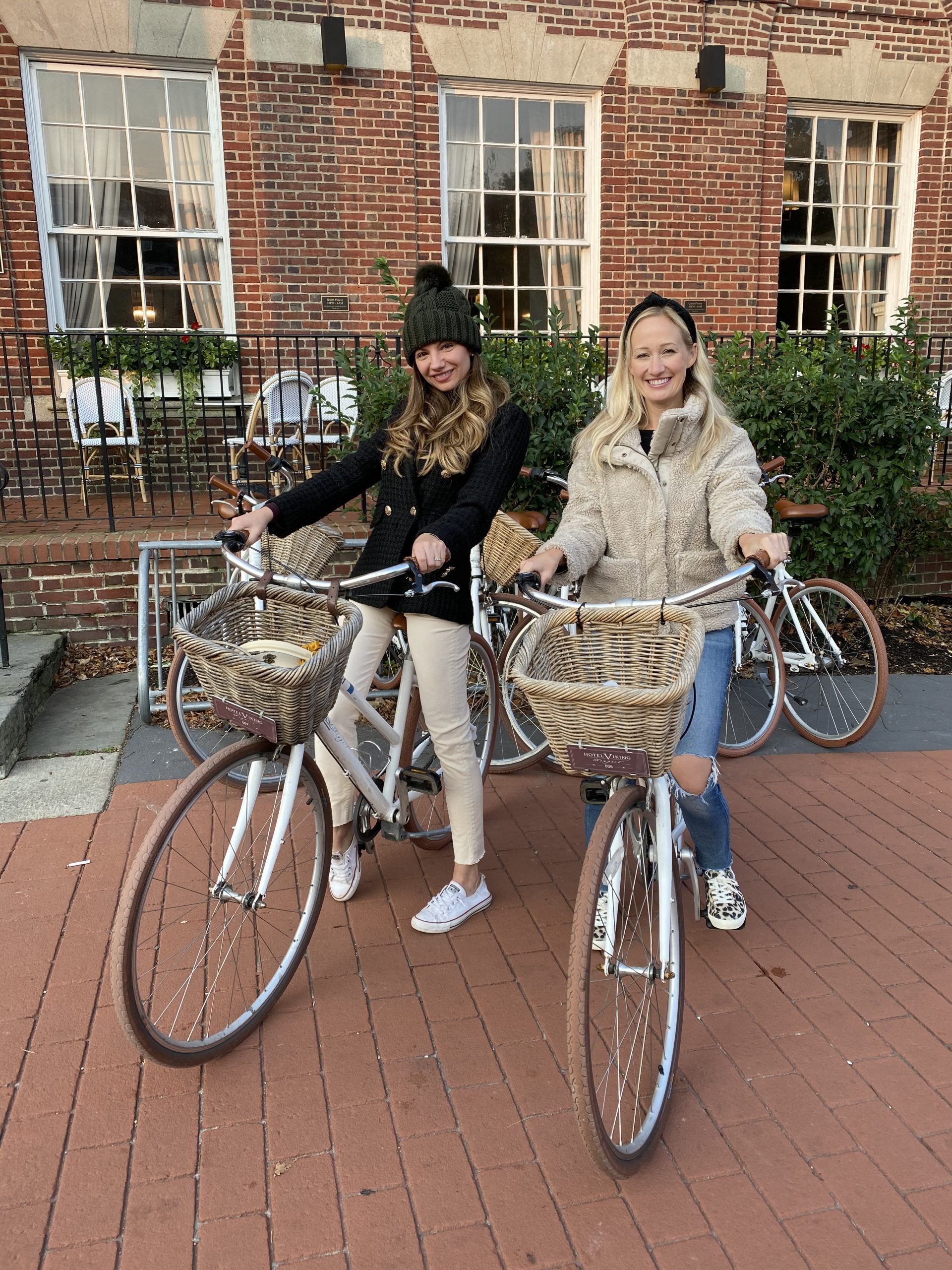 two women smiling on white bicycles 