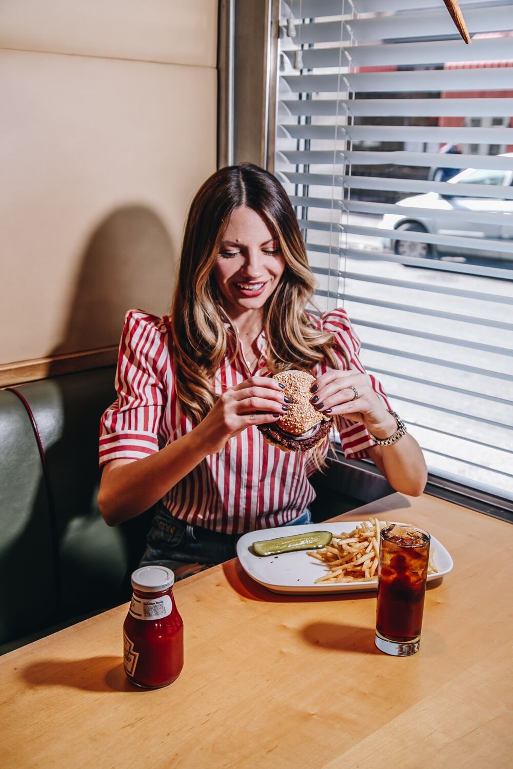 holding a burger in a diner