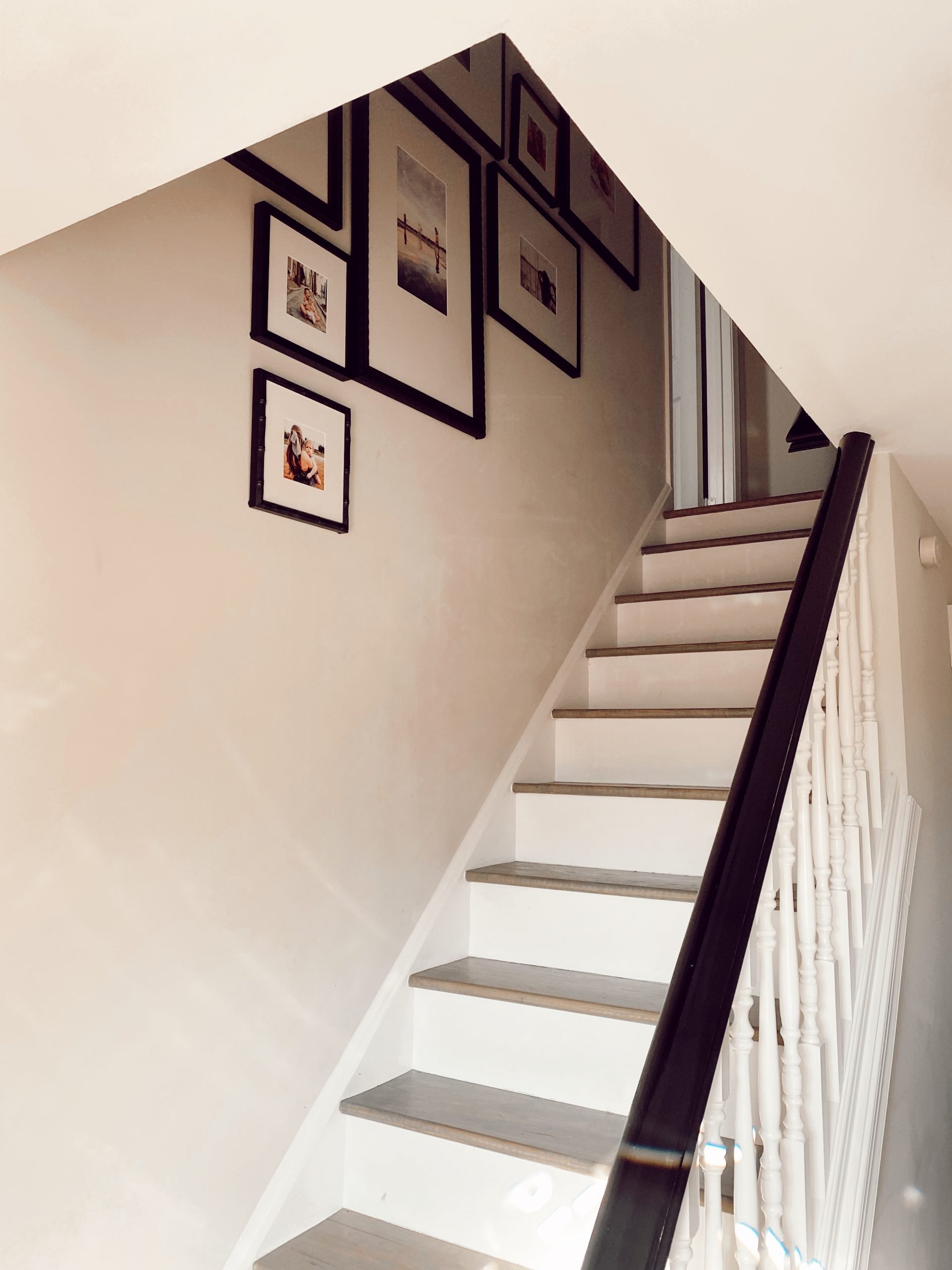 A staircase with white walls and a Framebridge Gallery Wall going up the stairs