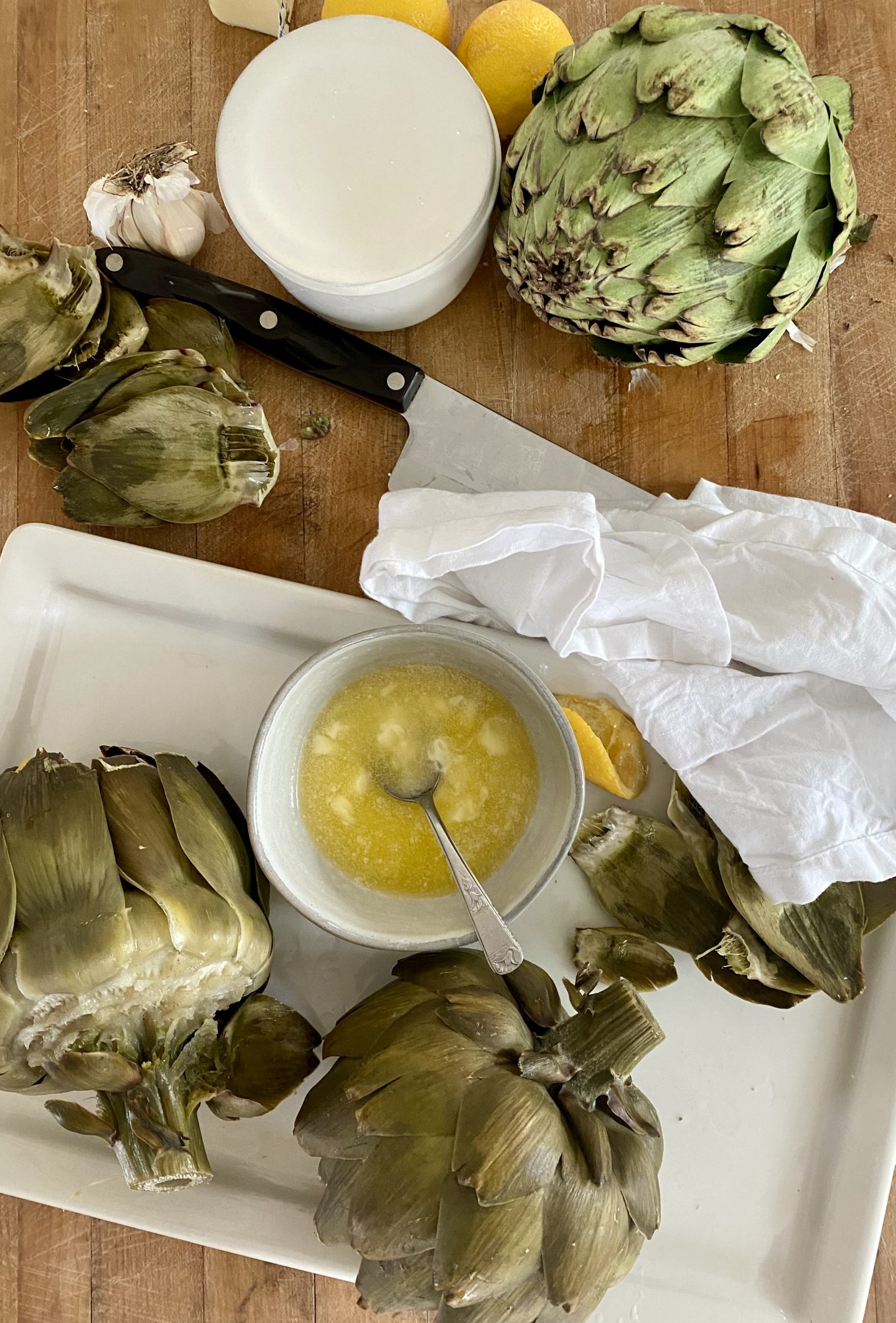 steamer artichokes with butter arranged on a tray. 