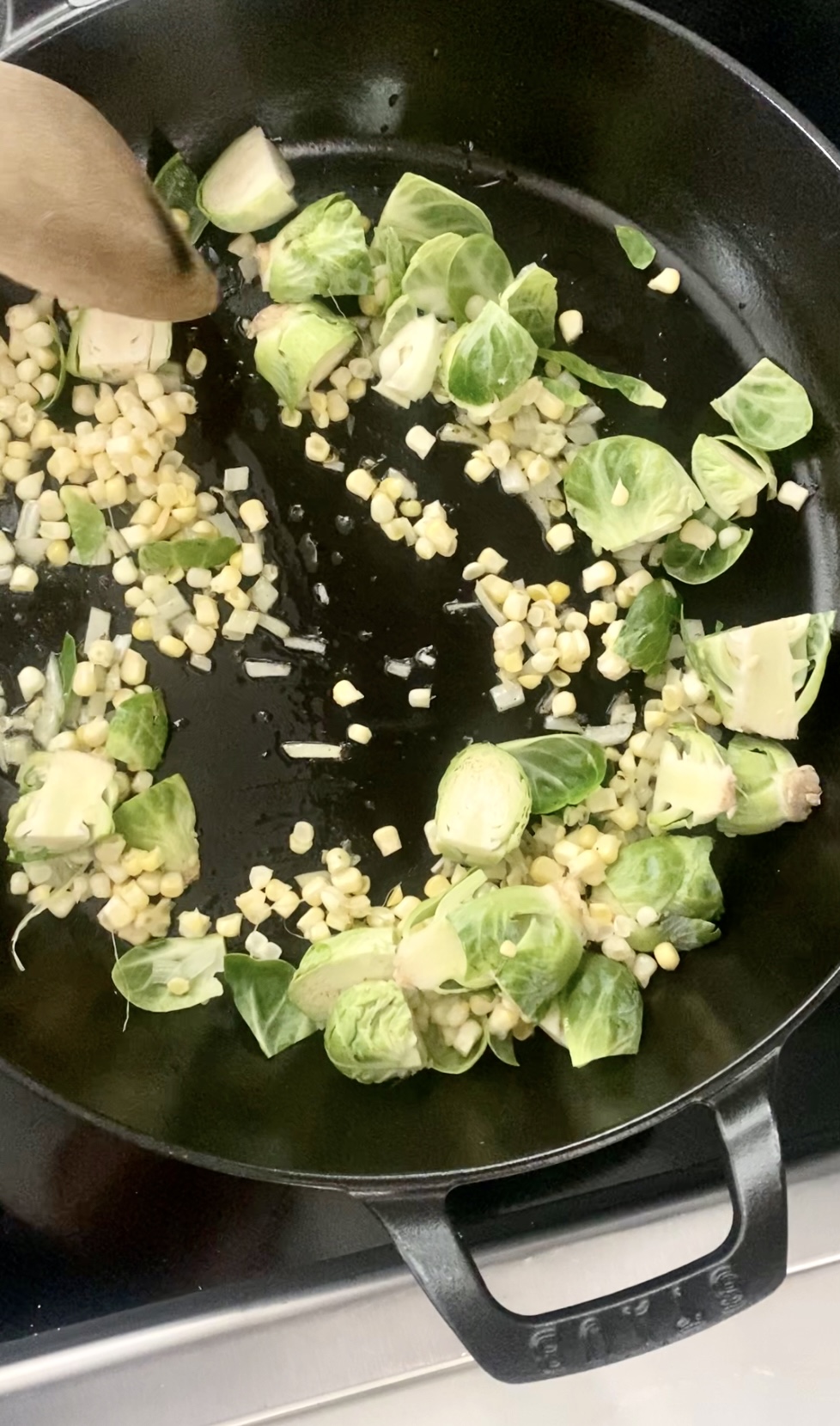 Brussel Sprouts, Corn and Shallot being salted in a stab oven pan. 