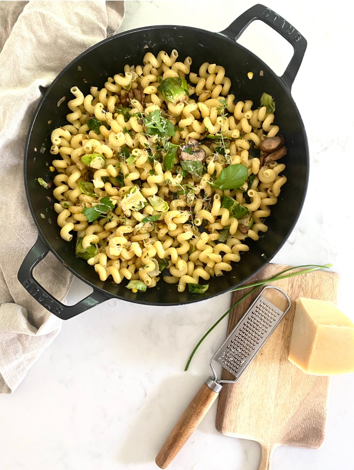 Easy Pasta Recipe in a black staub pan with mushrooms, herbs and corn. 